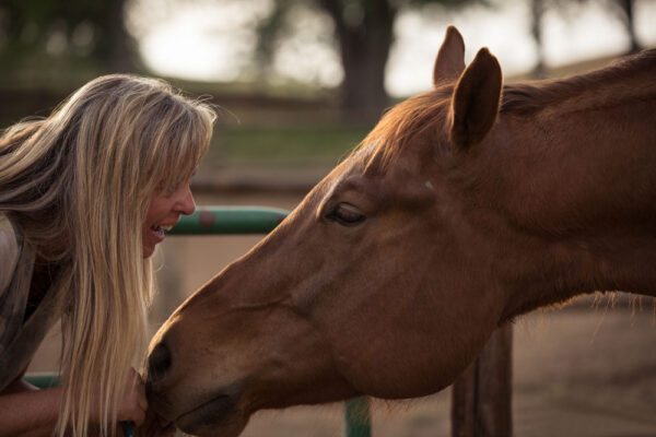 Debbie face to face with a horse smiling