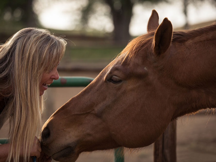 Debbie face to face with a horse smiling