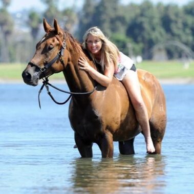 Debbie in the water sitting on a horse